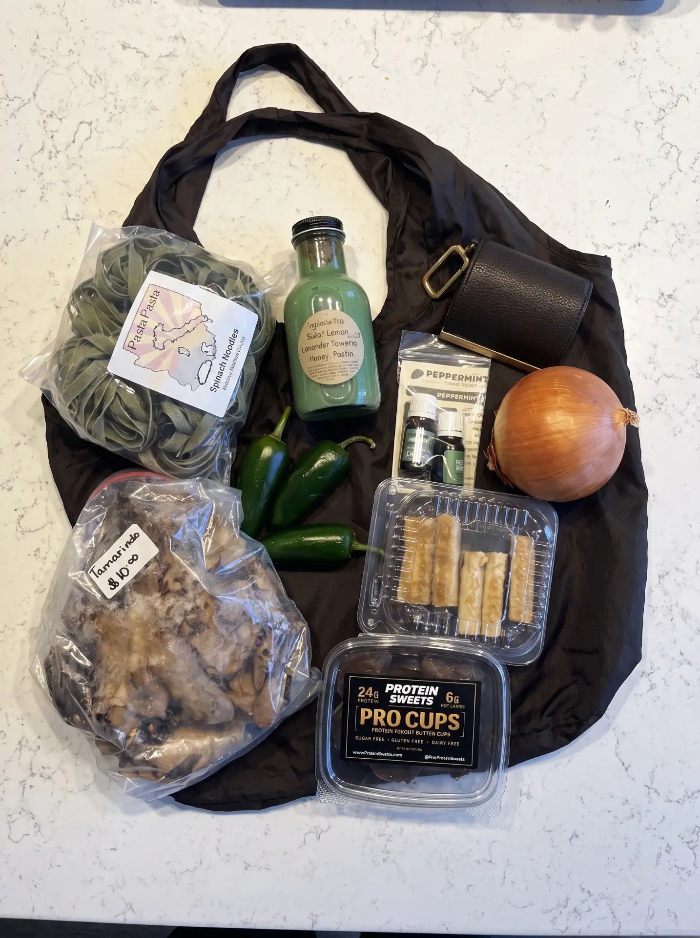 Black Cliqué Tote laid flat on a counter holding a full grocery shop