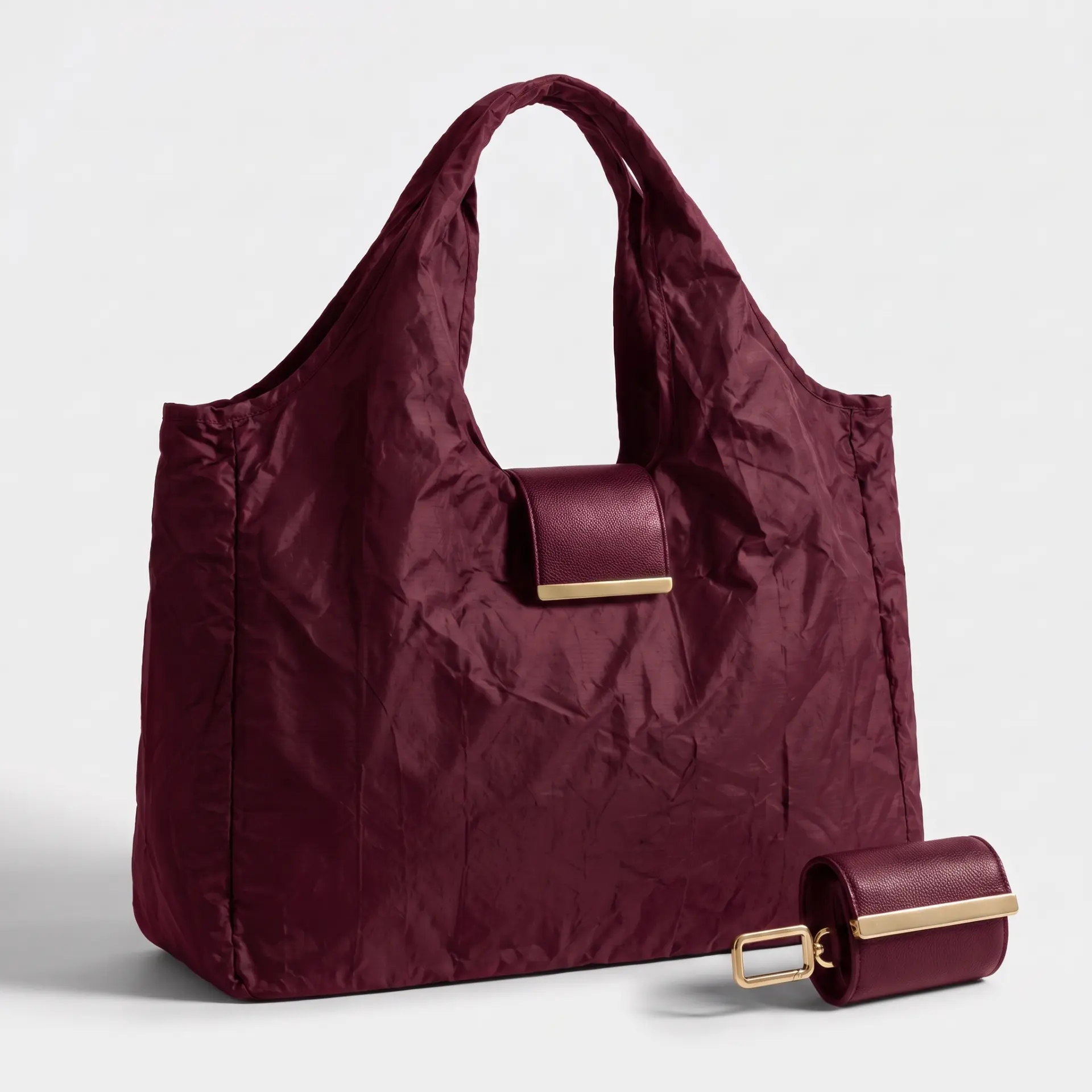 Burgundy Cliqué Tote beside its folded pouch with brushed gold hardware